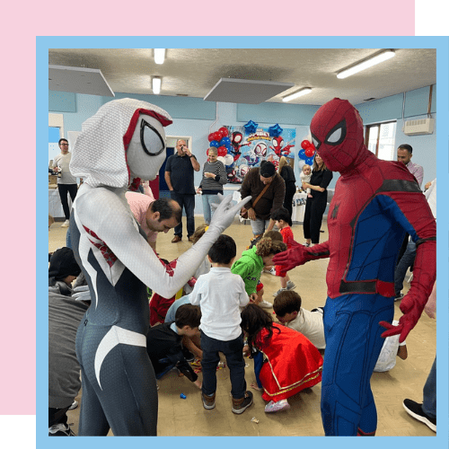 Spider-Man and Ghost Spider playing a game with a group of children